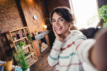 Wall Mural - Portrait of positive lovely lady make selfie arm touch cheek beaming smile spend free time loft flat inside