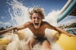 A happy man riding on the water slide in the waterpark.