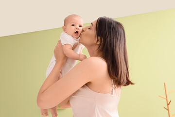 Sticker - Happy mother kissing her cute little baby in room at home