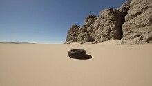 An Abandoned Tire Left In The Barren Desert Landscape