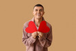 © Pixel-Shot - Happy young man with red paper hearts on brown background