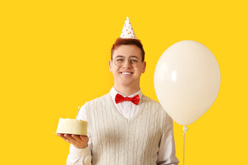 Sticker - Young man in party hat with air balloon and sweet cake celebrating Birthday on yellow background