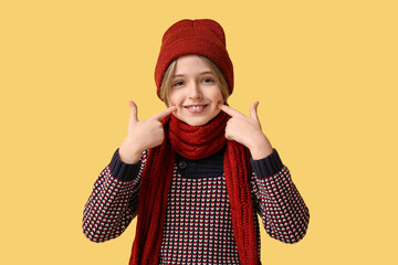 Canvas Print - Cute little boy in winter clothes on yellow background