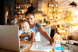 © Marko Geber - Mother working in home office with baby