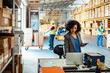 © Marko Geber - Professional woman working on laptop in warehouse