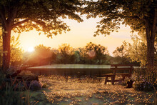 An Old Wooden Bench The Lakeside Is Calm On An Autumn Evening, The Atmosphere Glowing Orange From The Setting Sun. Surrounded By Beautiful Nature 3d Render