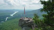 Chimney Rock With Flattering American National Flag And Many Tourists At Chimney Rock State Park In North Carolina, USA. Travel Destination Spot In Appalachian Mountains