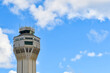© Ryan Tishken - Airport traffic control tower with clouds and blue sky background