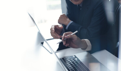 Canvas Print - Two businessmen having a discussion, working on laptop computer, using digital tablet and mobile phone during meeting at office. Business planning and solution, working together concept