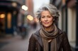 Portrait of a beautiful middle aged woman with grey hair in a city street