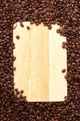 Wall Mural - Top view of roasted coffee beans texture background on flat lay in vertical with wooden board (cutting board) free space in center. pattern for design menu drink. coffee beans frame.