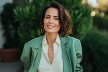 Portrait Of A Beautiful Young Business Woman In Green Suit Smiling At The Camera
