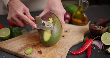 Canvas Print - Woman peeling mango on a wooden cutting board at domestic kitchen