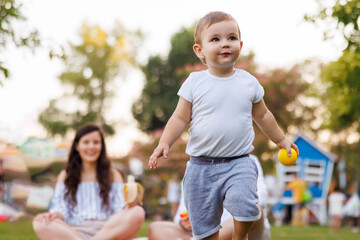 Wall Mural - Toddler having fun on picnic with parents