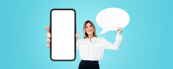 Smiling woman showing smartphone with mock up display and empty thought bubble