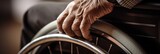 Fototapeta  - Close-up of an elderly hand gripping a wheelchair wheel, highlighting the challenges of mobility