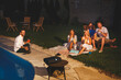 © Impact Photography - Friends having fun watching a movie in home backyard open air cinema