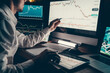 © gstockstudio - Close-up of male trader planning business strategy while pointing computer monitor in night office