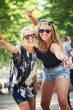 © M Moller/peopleimages.com - Portrait, outdoor and women with celebration, event and nature with happiness, dancing and cheerful. Face, people and friends with music festival, concert and energy with culture, sunglasses and joy