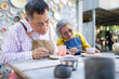 © Wosunan - In the pottery workshop, an Asian retired couple is engaged in pottery making and clay painting activities.