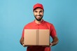 A man in a red shirt holding a cardboard box