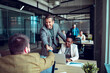 © Marko Geber - Smiling businessman shaking hand with colleague in office