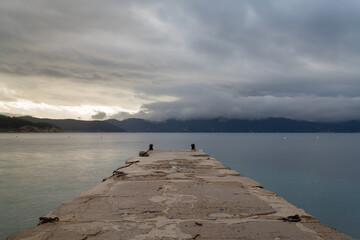 Wall Mural - view of the stone dock leading out into the ocean at Enfola Beach on Elba Island