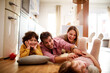 © Geber86 - Happy family sitting on floor having fun at home