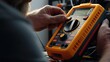 A man is holding a multimeter in his hand. This versatile tool can be used for electrical measurements in various settings