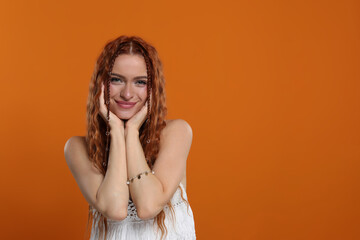 Poster - Beautiful young hippie woman on orange background, space for text