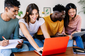 Young group of college students learning together using laptop computer at home. College classmates working on university assignment homework project at share flat