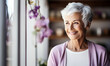 Radiant senior woman with stylish short white hair and a lilac cardigan, smiling warmly in a light, modern setting, embodying grace and positivity