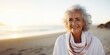 Smiling attractive beautiful caucasian senior mature woman posing at the beach looking at the camera