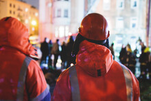 Group Of Fire Men In Protective Uniform During Fire Fighting Operation In The Night City Streets, Firefighters Brigade With The Fire Engine Truck Vehicle, Emergency And Rescue Service
