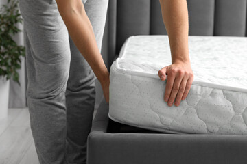 Wall Mural - Man putting soft mattress on bed, closeup