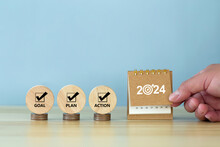 Happy New Year 2024 Banner Background. 2024 Numbers Year With Target Dart Icon On Desk Calendar With Hand Turns Over A Calendar Sheet.  Goal, Plan, Action On Wooden Cube. Business Goals Plan Action.