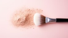 Makeup brush with rice loose face powder on light pink background, top view. 
