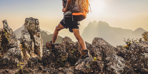 Hiker with backpack walking on top mountain sunset background. Hiker men's hiking living healthy active lifestyle.