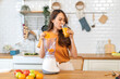 © Art_Photo - Portrait of beauty healthy asian woman making orange fruit smoothie with blender.girl preparing cooking detox cleanse with fresh orange juice in kitchen at home.health, vitamin c, diet, healthy drink.