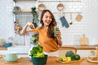 Portrait of beauty healthy asian woman making green vegetables detox cleanse and green fruit smoothie with blender.young girl drinking glass of smoothie, fiber, chlorophyll in kitchen.Diet, healthy.