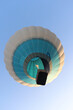 A balloon with people flies against the blue sky