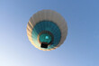 A balloon with people flies against the blue sky