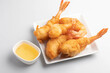 Battered shrimp with plum sauce in white plate