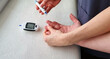 © Four_Lakes - Close up shot of the glucometr instrument on the white surface. Nurse helping patient to check sugar level. Healthcare