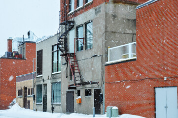 Canvas Print - Building facades in a Montreal alley during a snowfall