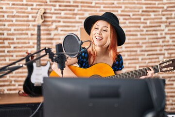 Sticker - Young caucasian woman musician singing song playing classical guitar at music studio