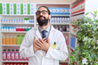 © Krakenimages.com - Hispanic man with beard working at pharmacy drugstore smiling with hands on chest with closed eyes and grateful gesture on face. health concept.