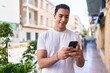 © Krakenimages.com - Young hispanic man smiling confident using smartphone at street