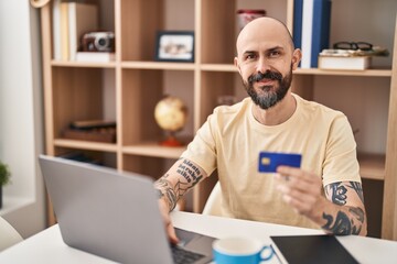 Sticker - Young bald man using laptop and credit card sitting on table at home