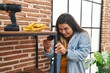 © Krakenimages.com - Young beautiful plus size woman smiling confident repairing shelving at new home
